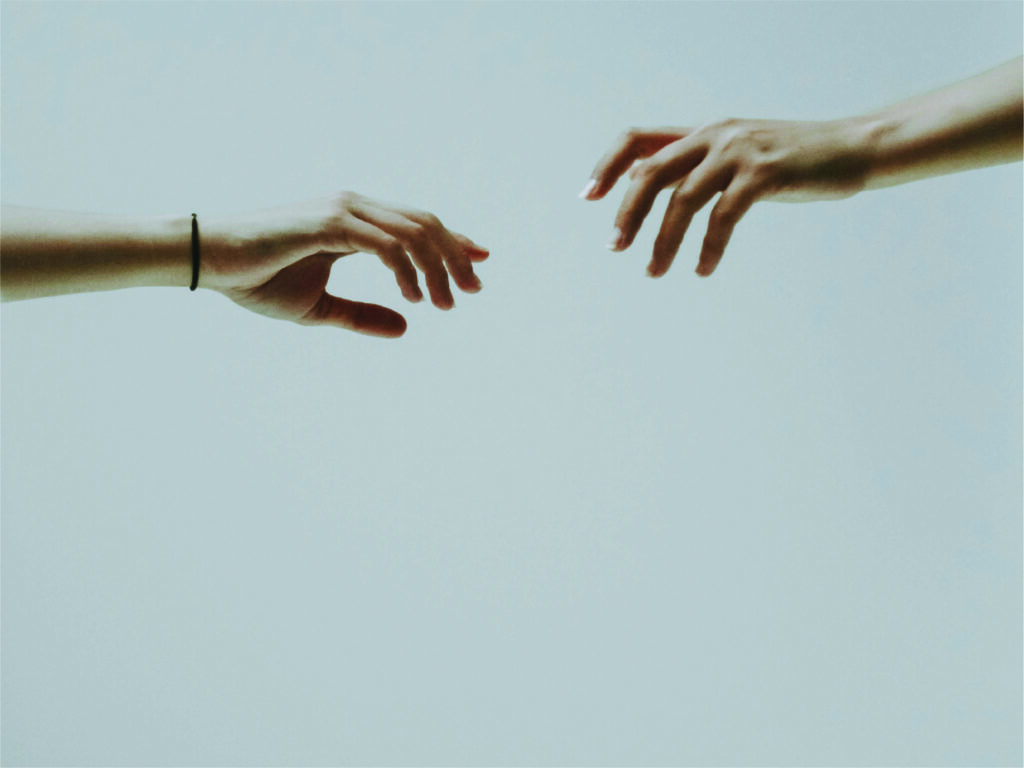 Two hands reaching towards eachother